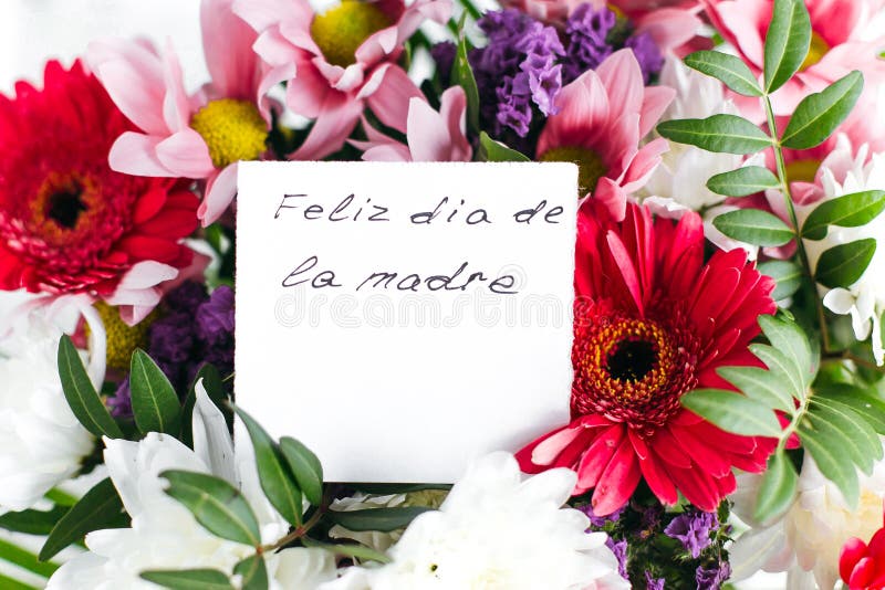 White card for a bouquet with the inscription Happy Mother`s Day in spanish in a bright beautiful bouquet. Of flowers royalty free stock photos