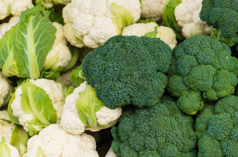 White Cauliflower and Broccoli Heads in a Crate on the Market Stock