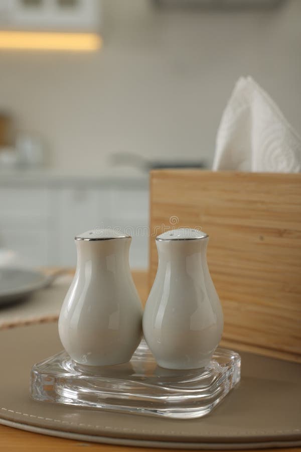 White Ceramic Salt and Pepper Shakers on Wooden Table, Space for Text
