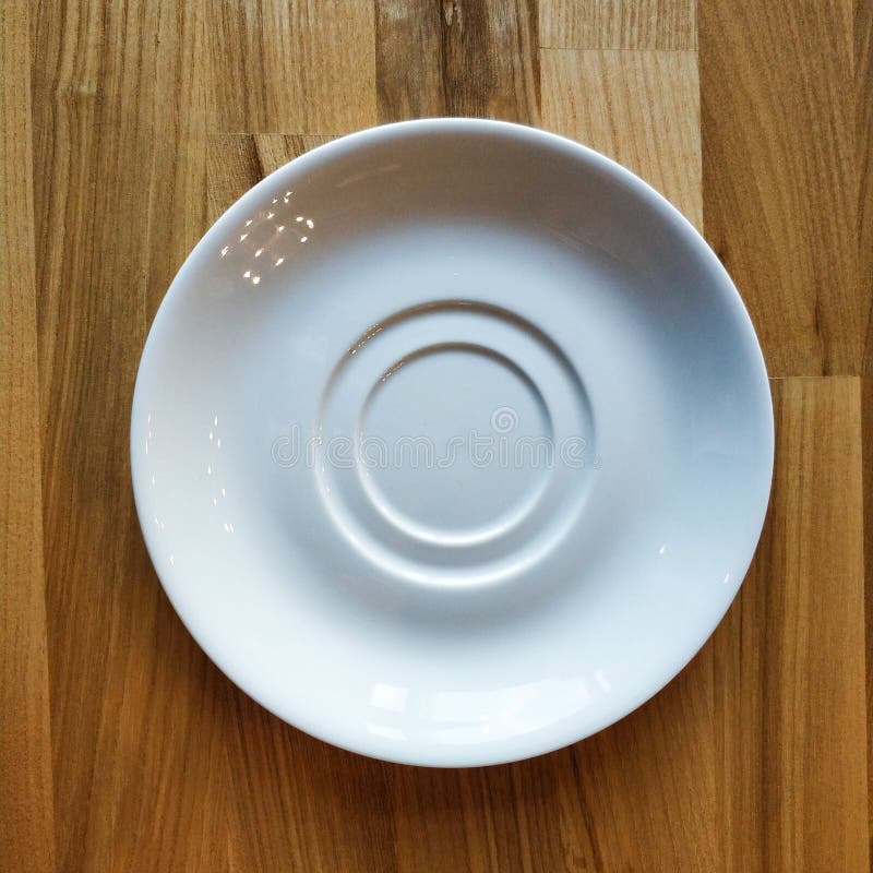 White Ceramic Saucer on a Wooden Table. Clean Dishes Stock Image