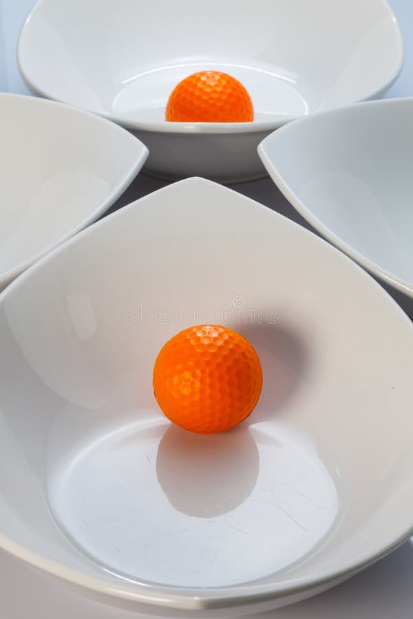 White Ceramics Bowls and Orange Golf Ball Stock Image Image of mirror