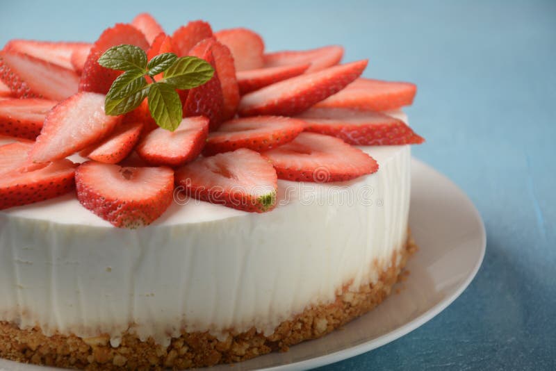 White cheese cake with strawberries garnished with mint. Sweet dessert