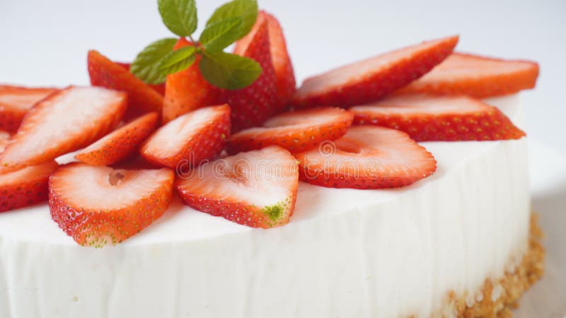 White cheese cake with strawberries garnished with mint. Sweet dessert