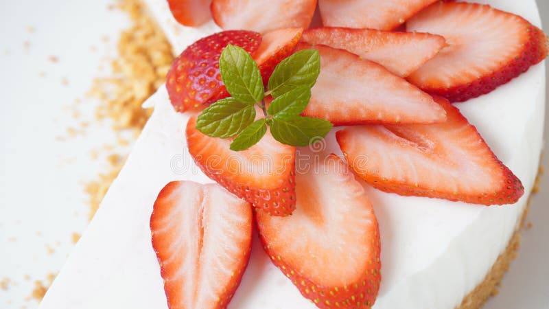 White cheese cake with strawberries garnished with mint. Sweet dessert