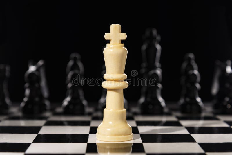 White chess queen on a chessboard against black chess pieces. One against all