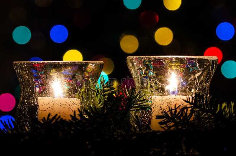 White Christmas Candles Surrounded by Christmas Lights and Evergreen