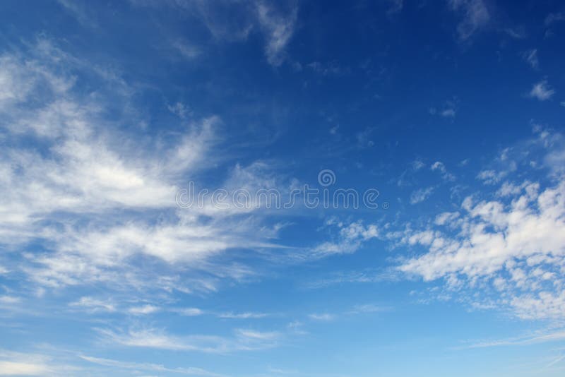 White cirrus clouds against the dark blue sky.