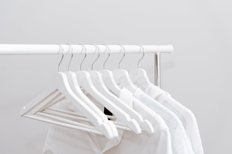 White Clothes Hanging in Row on White Coat Hangers. Stock Photo - Image ...