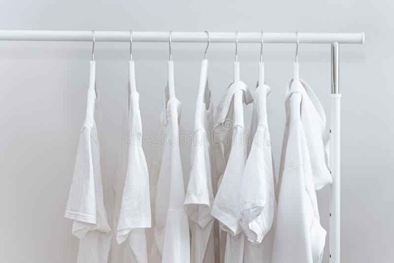 White Clothes Hanging in Row on White Coat Hangers. Stock Photo - Image ...
