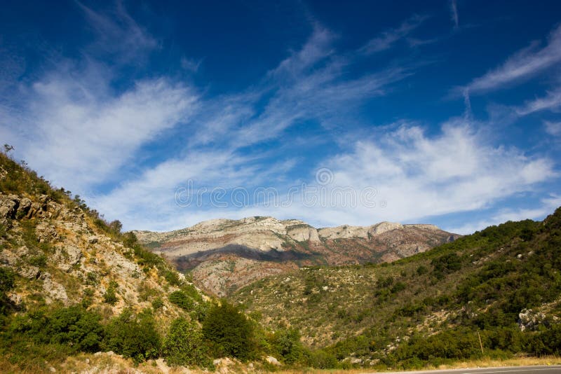 White clouds in the blue sky over the mounts.