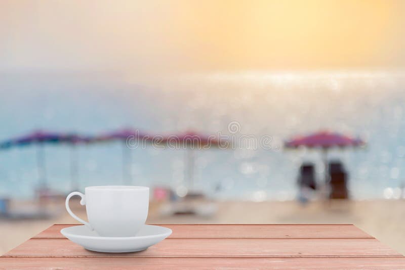 White Coffee cup on the wood table with blur scenery sea beach b