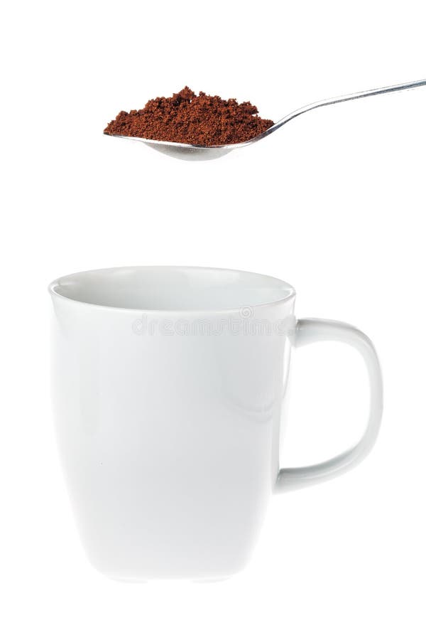 White coffee mug with a teaspoon of granulated instant coffee above the cup ready to be tossed into, isolated on white. White coffee mug with a teaspoon of granulated instant coffee above the cup ready to be tossed into, isolated on white