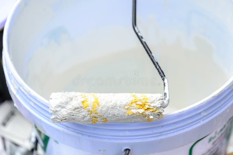 White Color in Bucket for Paint Wall with Paint Roller Stock Photo