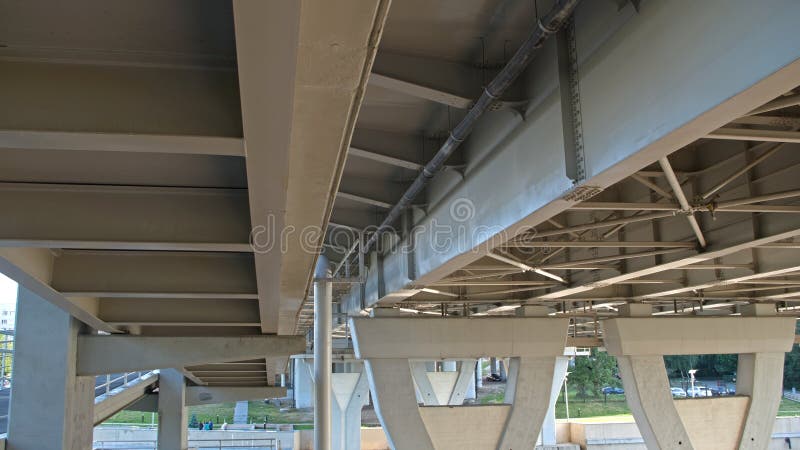 White long overpass bridge. Bottom view of the support structure. White concrete extended trestle bridge. Bottom view of the supports, floors, and sections of the structure.