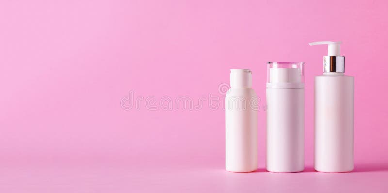 White cosmetic tubes on pink background with copy space. Skin care, body treatment, beauty concept