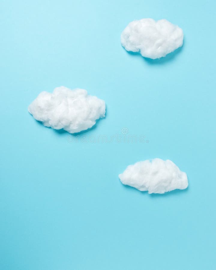 White cotton clouds on pastel blue background. Minimal concept