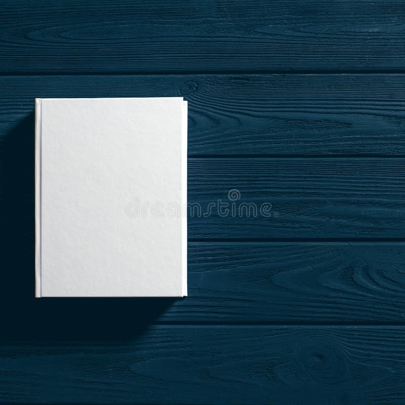 The white-cover book is on a textured wooden table stock photography The white-cover book is on a textured wooden table stock photography