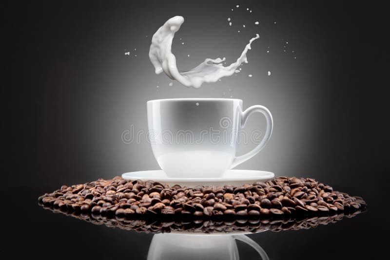 White cup with coffee beans and milk splash
