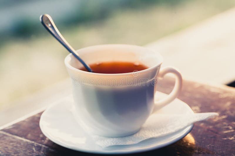 White cup of tea on a edge of wooden table