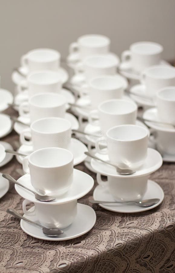 White Cups for Tea with Spoons on Table with Tablecloth for Coffeebreak. Stock Photo Image of