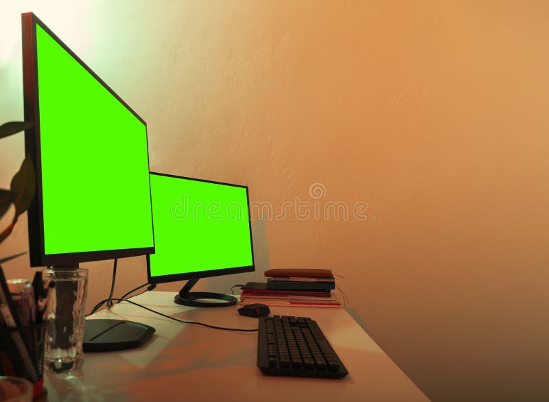 White Desk with Two Monitors on it Green Screens Turned on for Copy