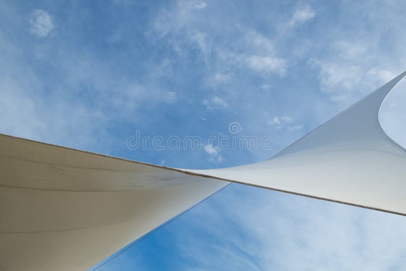 White detail of big top tent against a blue an cloudy sky