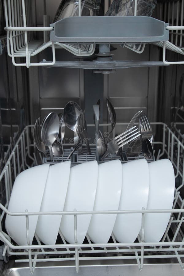 White Dishes in the Dishwasher. Homework with Dishwasher Concept Stock