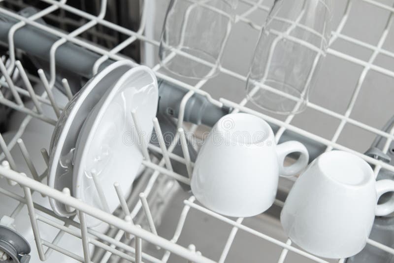 White Dishes in the Dishwasher. Homework with Dishwasher Concept Stock