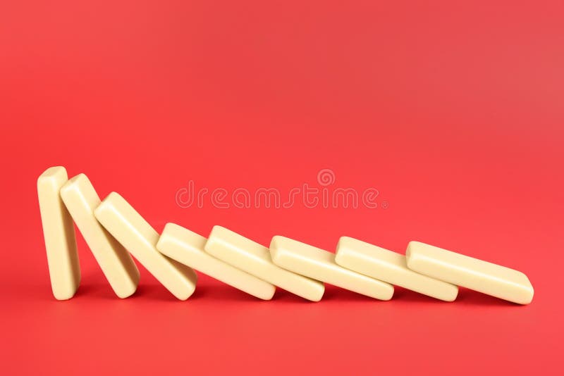 White domino tiles falling on red background. Space for text stock photos