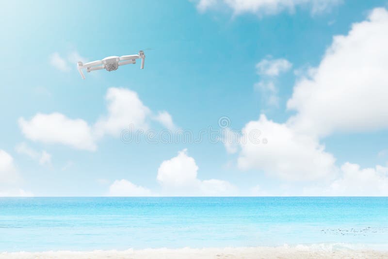 White drone with camera flying over the beach with blue ocean royalty free stock photo White drone with camera flying over the beach with blue ocean royalty free stock photo
