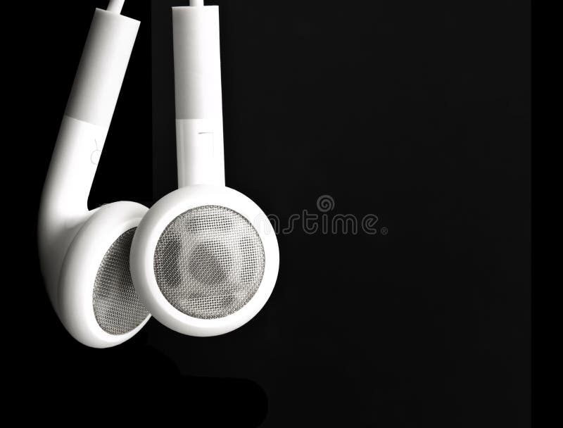 White earbuds hanging on a black background