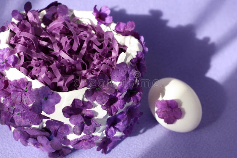 A White Easter Basket Decorated with Purple Flowers and a White Egg