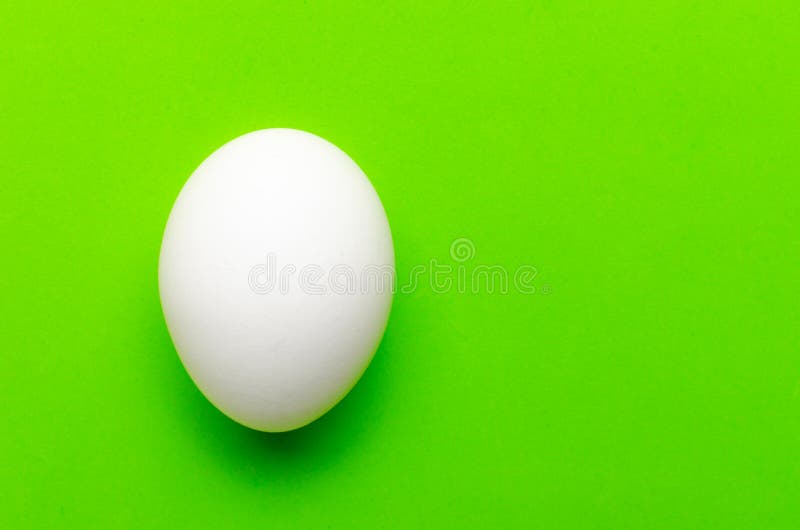 Symmetry Of White Eggs On Bright Light Green Background. Stock Photo