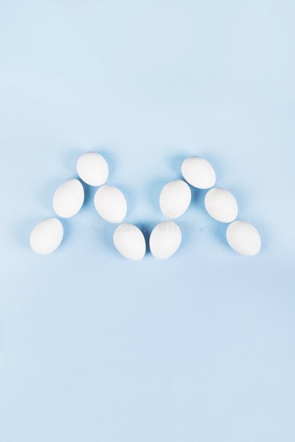 White eggs in form of letter m on blue background. Concept gender stereotypes, role of man and woman in society. stock image White eggs in form of letter m on blue background. Concept gender stereotypes, role of man and woman in society. stock image