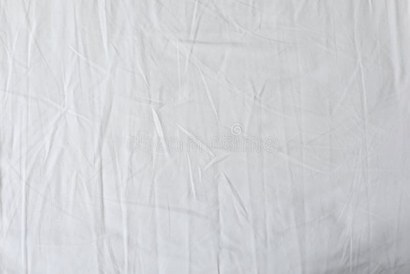 White fabric texture background. Wrinkled, crumpled fabric. Top view of unmade bed sheet after night sleep. Soft focus royalty free stock image White fabric texture background. Wrinkled, crumpled fabric. Top view of unmade bed sheet after night sleep. Soft focus royalty free stock image