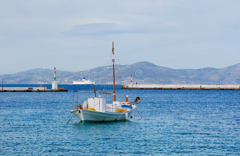 White fishing boat in the blue sea at anchor.