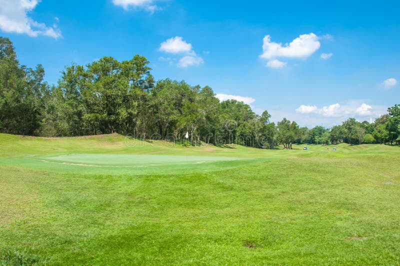 White flag with blue sky in golf course green grass royalty free stock images