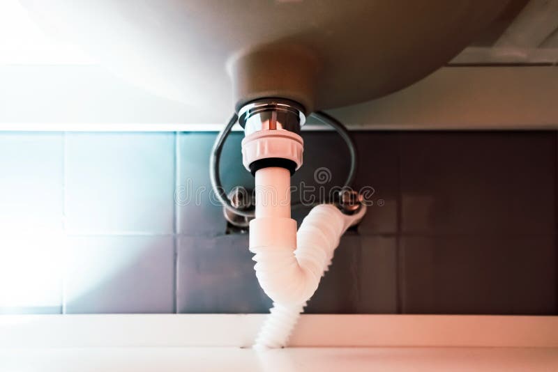 White Flexible Drain Pipe from a Sink Installed in a Bathroom Stock