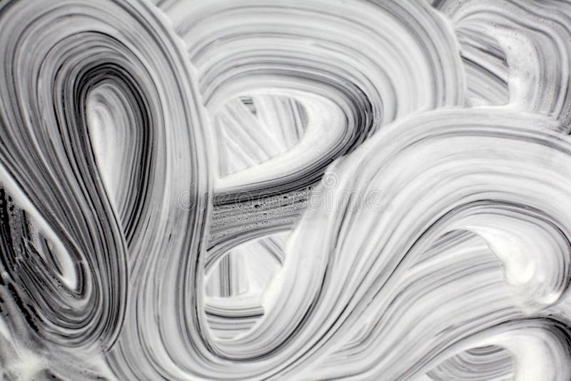 White Foamy Wave Stains on a Smooth Black Surface. Abstract Texture