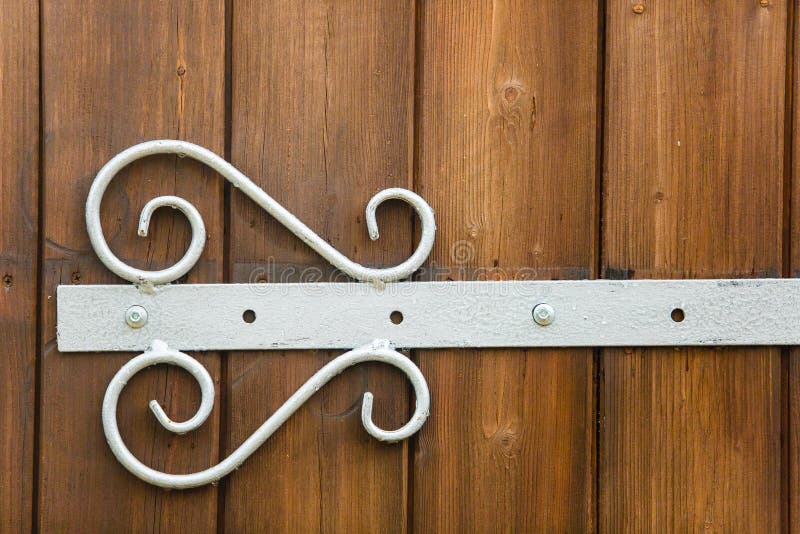 White forged hinge put on wooden door close-up