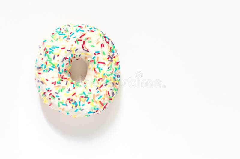 White Frosted Donut with Colorful Sprinkles on White Background Stock