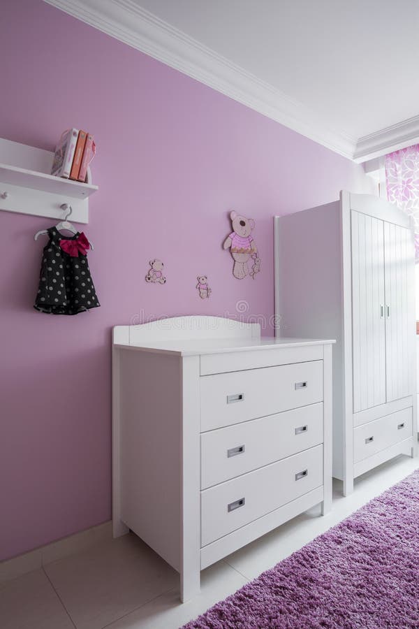 White furniture and rose wall in baby's room. White furniture and rose wall in baby's room