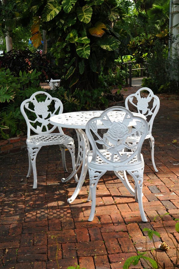 White garden chairs in a backyard patio royalty free stock photos