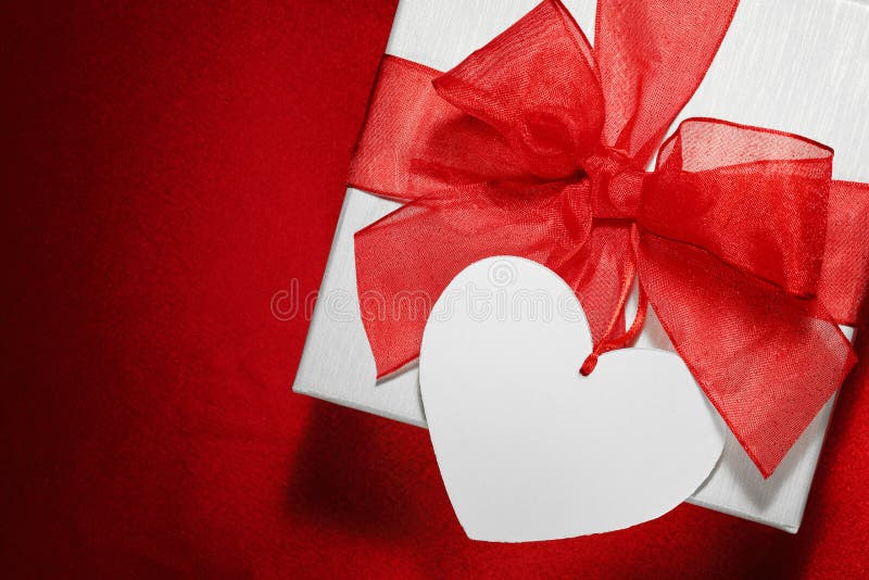 White gift box. With blank tag on red background royalty free stock image White gift box. With blank tag on red background royalty free stock image