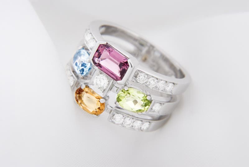 White gold ring with citrine peridot, blue topaz, pink tourmaline and diamonds on soft white stock images White gold ring with citrine peridot, blue topaz, pink tourmaline and diamonds on soft white stock images