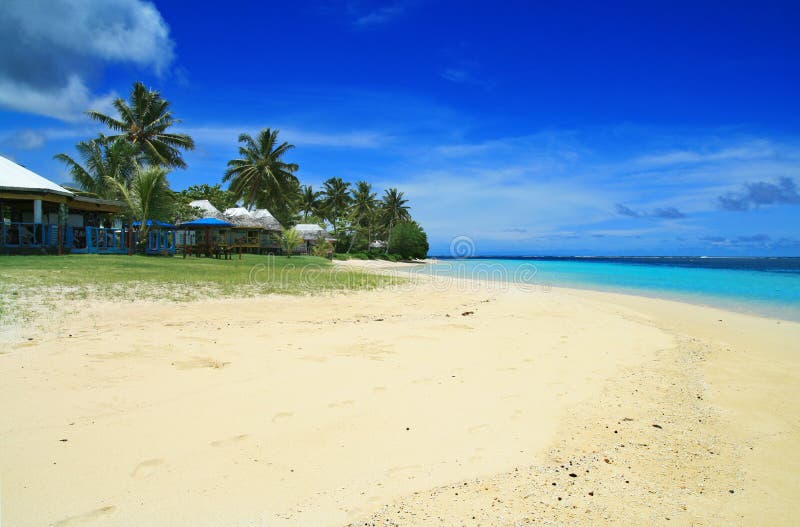 White golden sand and coral blue sea waters with Polynesian beachfront houses- beach fales, Manase, Samoa, Savai`i royalty free stock photography White golden sand and coral blue sea waters with Polynesian beachfront houses- beach fales, Manase, Samoa, Savai`i royalty free stock photography