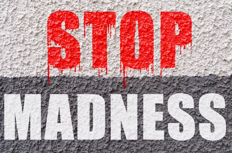 On the white-gray surface of the wall is the inscription - stop madness stock photos