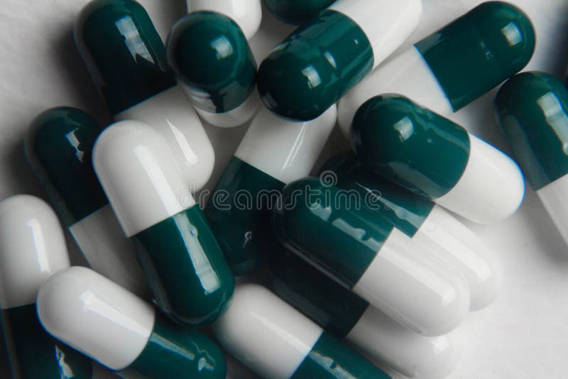 white-green pill capsules close up on white background, medical concept, to...