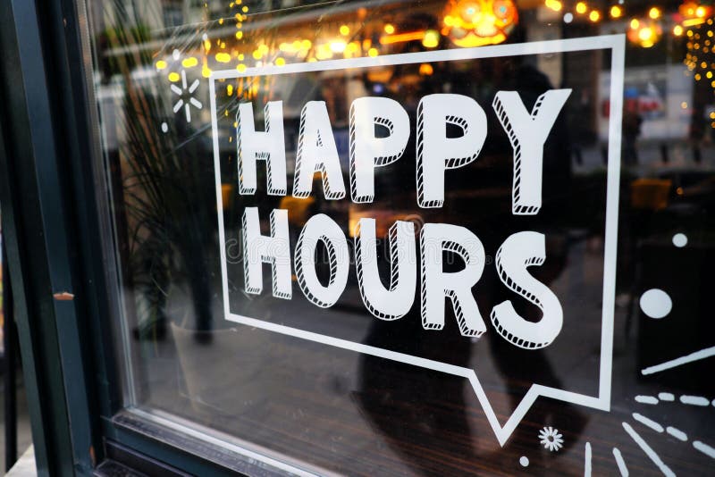 White `happy hours` sign on restaurant window with beautiful bokeh balls in the background