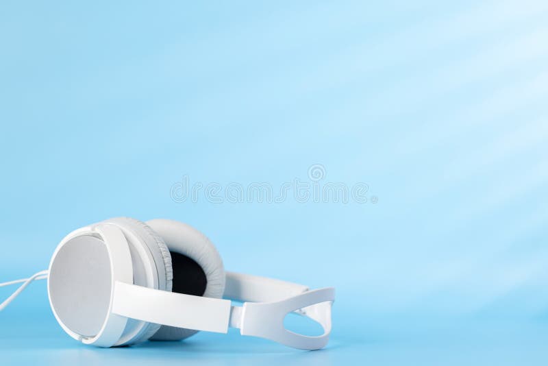 White headphones on blue stock image. Image of equipment 273413035